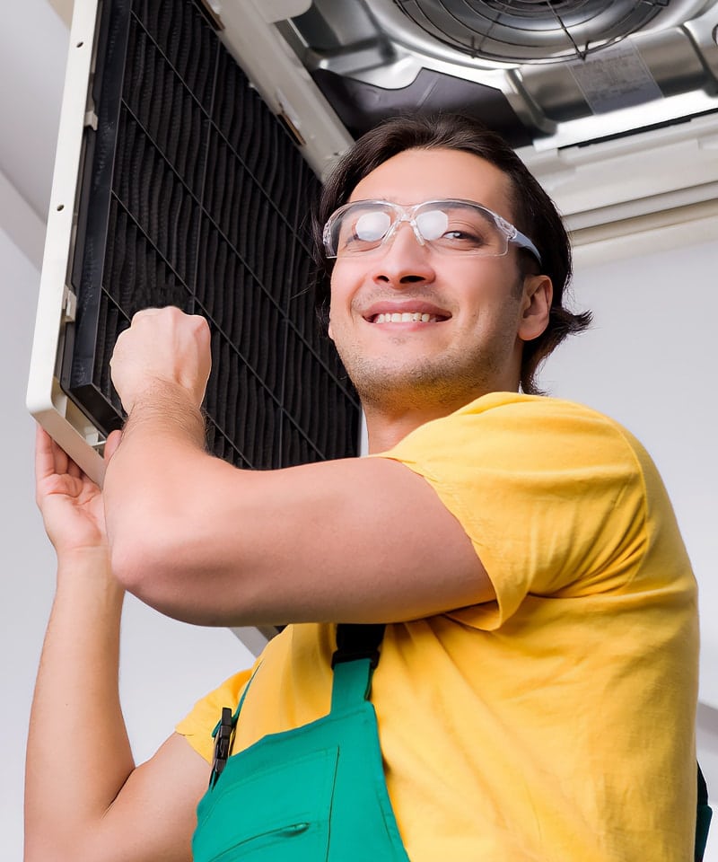 Technician Smiling While Inspecting HVAC System Installation in a Building