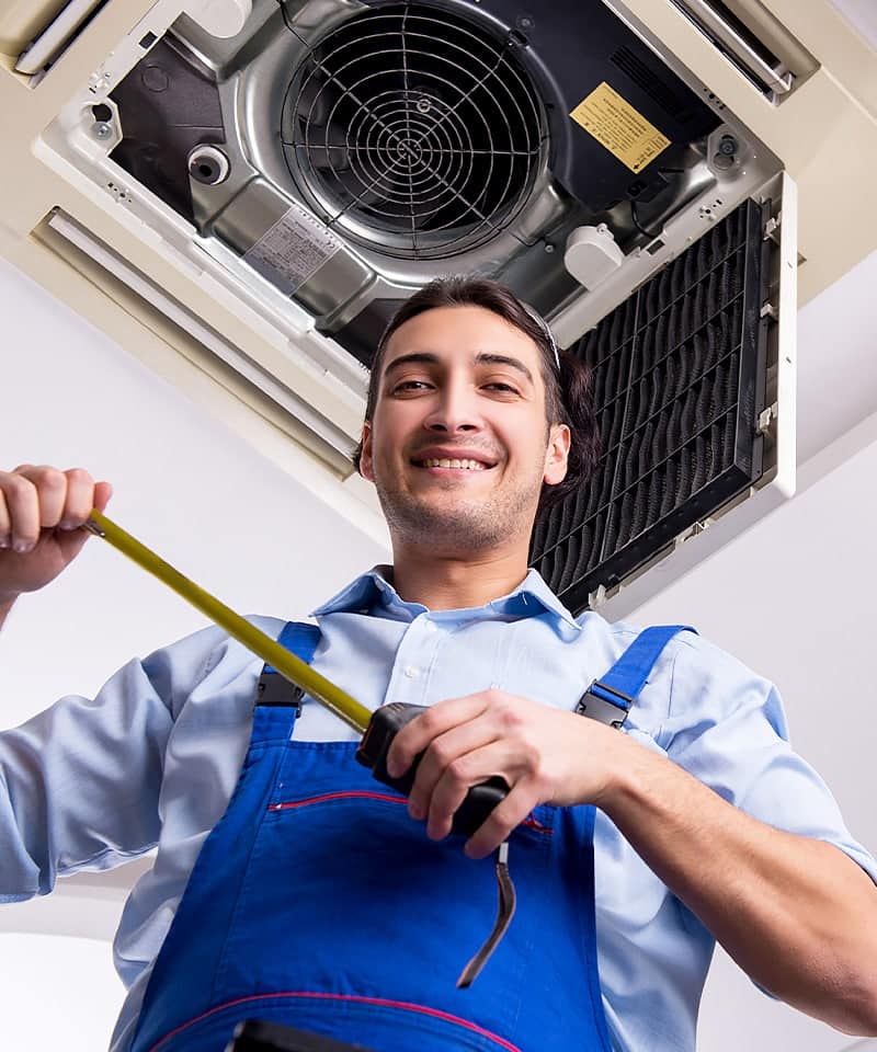 Technician Measuring for HVAC System Installation Under Ceiling Unit
