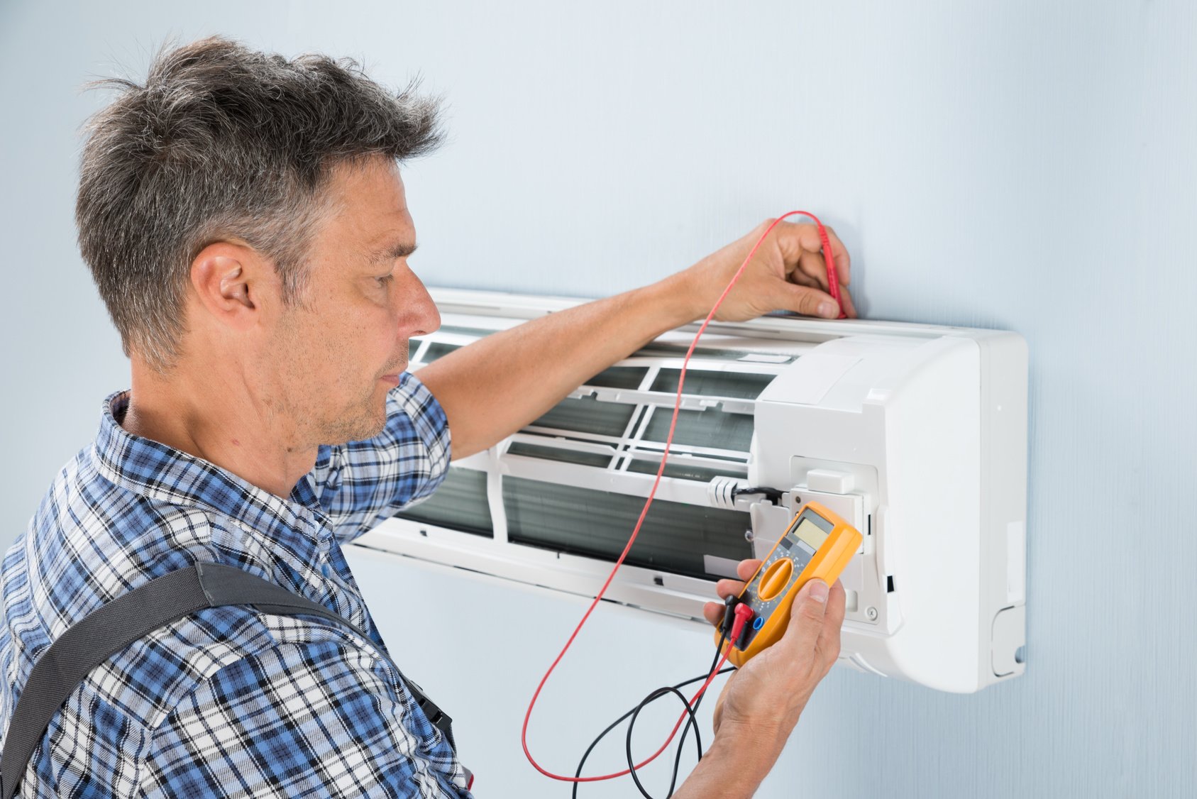 Technician Inspecting AC Unit for HVAC Repair Service